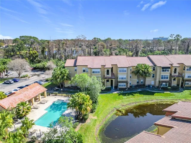 an aerial view of a house with swimming pool and a yard