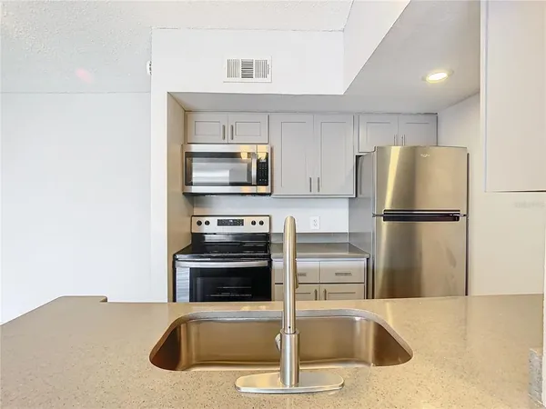 a kitchen with a refrigerator a stove and a sink