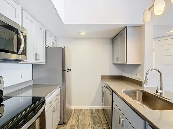 a kitchen with stainless steel appliances granite countertop a sink stove and refrigerator