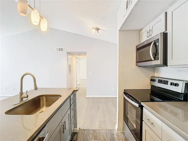 a kitchen with stainless steel appliances granite countertop a sink stove and microwave