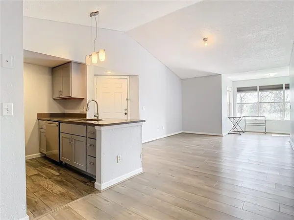 a kitchen with granite countertop a stove a sink and a wooden floor