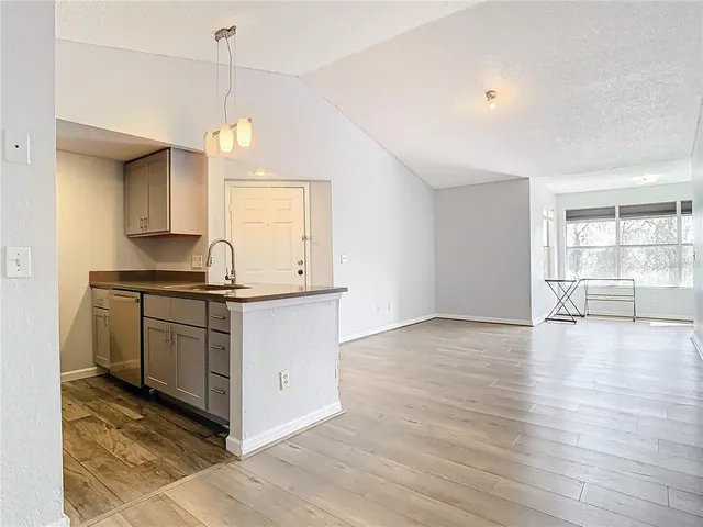 a kitchen with granite countertop a stove a sink and a wooden floor