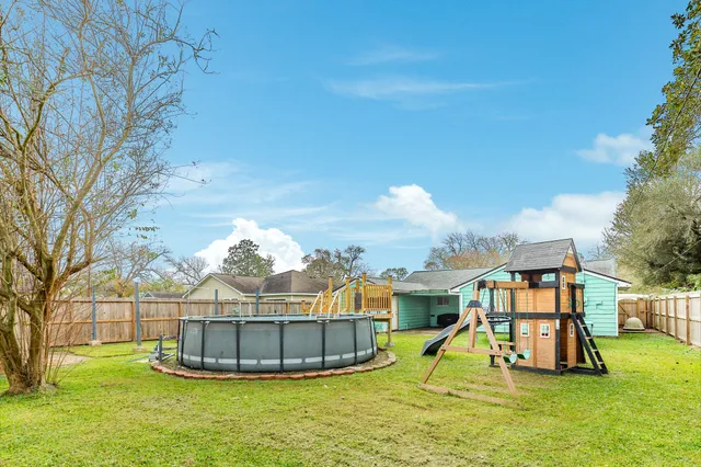 a view of a house with a yard and a slide