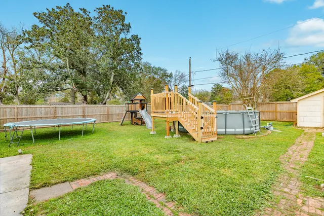 a white house with a big yard and large trees