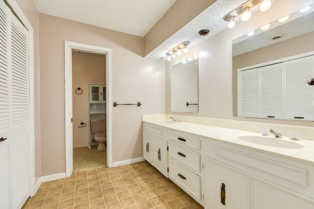 a spacious bathroom with double sink and a mirror