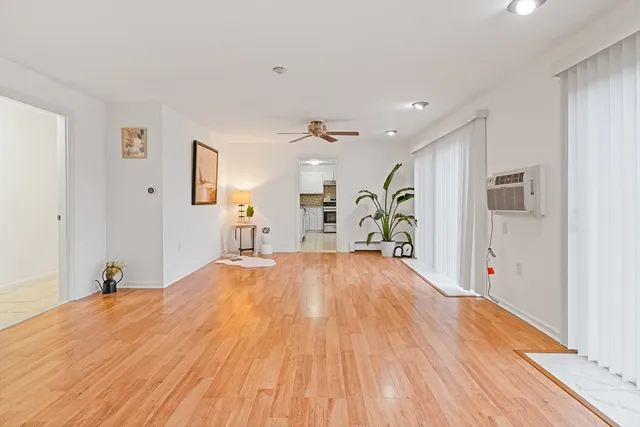 a big room with wooden floor and natural light
