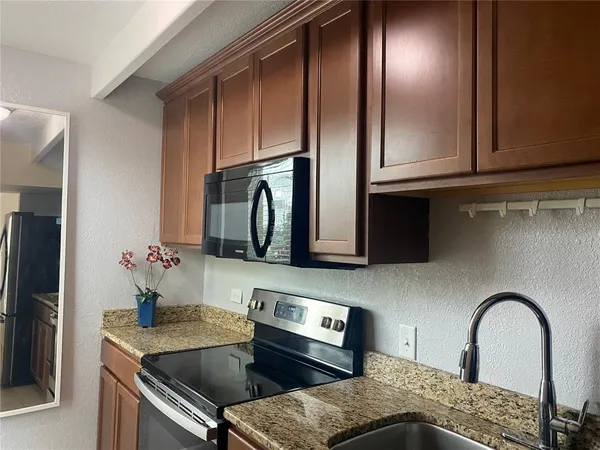 a kitchen with stainless steel appliances granite countertop a refrigerator and a stove