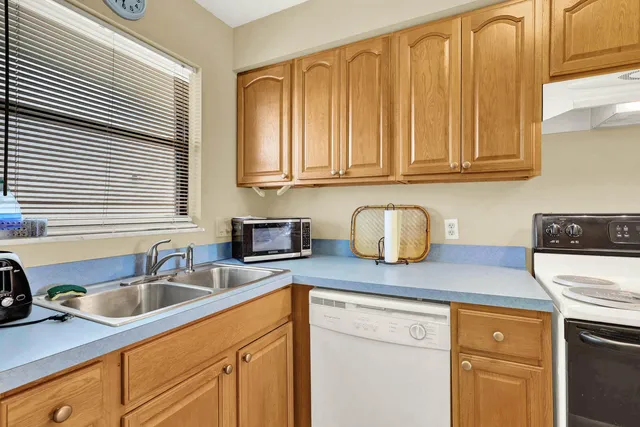 a kitchen with granite countertop a sink and a white wooden cabinets