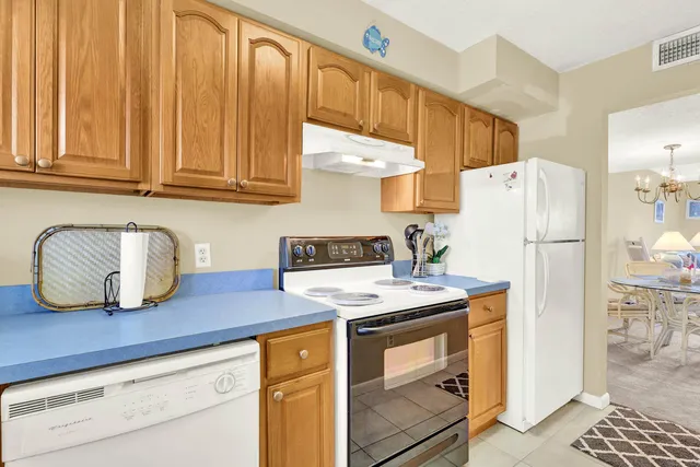 a kitchen with a refrigerator and a stove top oven
