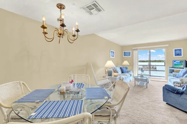 a view of a dining room with furniture a chandelier and wooden floor