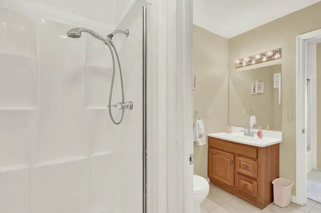 a bathroom with a sink toilet vanity and shower