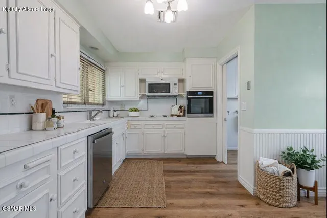 a kitchen with granite countertop white cabinets and white appliances
