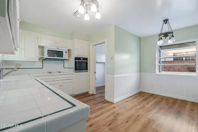 a kitchen with stainless steel appliances granite countertop a refrigerator and a stove top oven