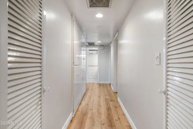 a view of a hallway with wooden floor