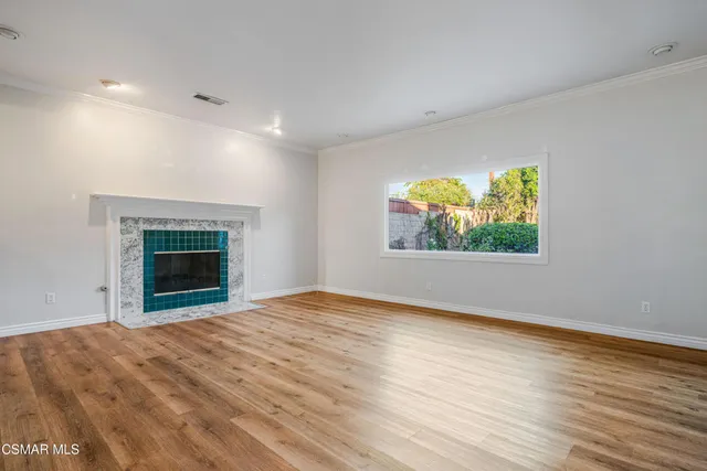 an empty room with windows and fireplace