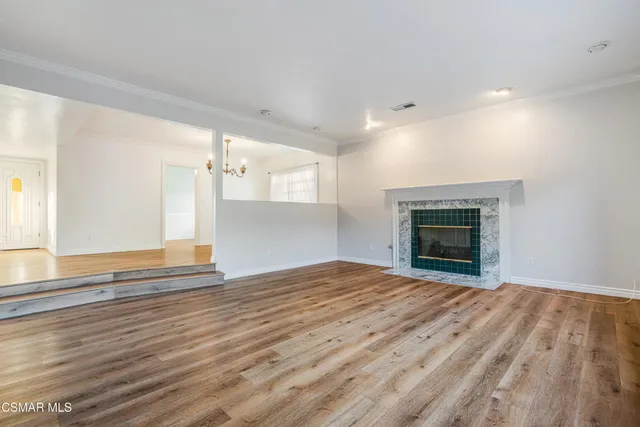 a view of empty room with wooden floor and fireplace