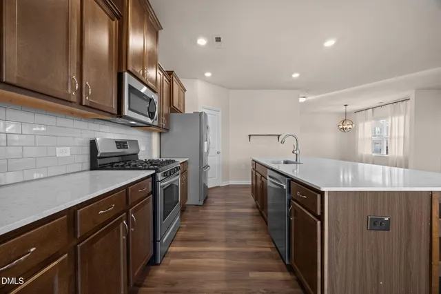 a kitchen with stainless steel appliances granite countertop lots of counter space a sink and cabinets