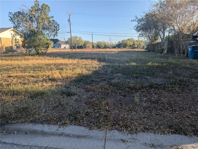 a view of a yard with wooden fence