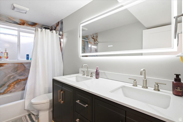 2973 West Red Sand Rd Haven Ogden, UT 84401 - Photo 24 of 30 Dual vanity with integrated sinks, brushed nickel fixtures, a white countertop, and dark wood cabinetry