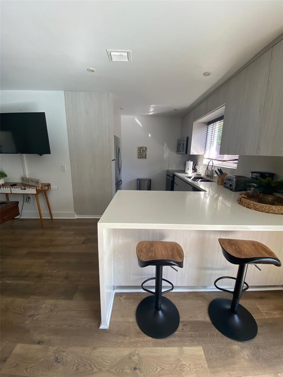 201 Northeast 48th Street Miami, FL 33137 - Photo 11 of 19 a living room with kitchen furniture and a flat screen tv