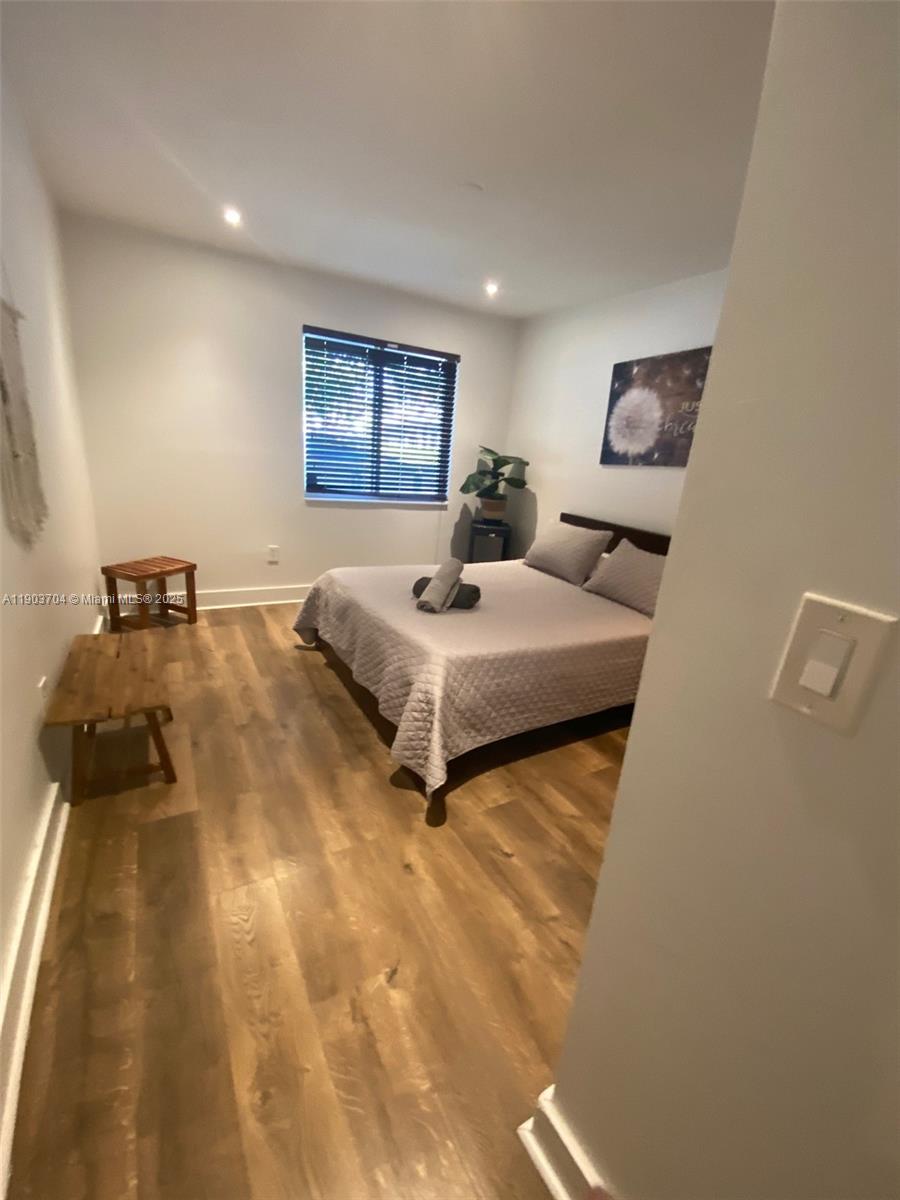 201 Northeast 48th Street Miami, FL 33137 - Photo 10 of 19 a bedroom with a bed and a night stand