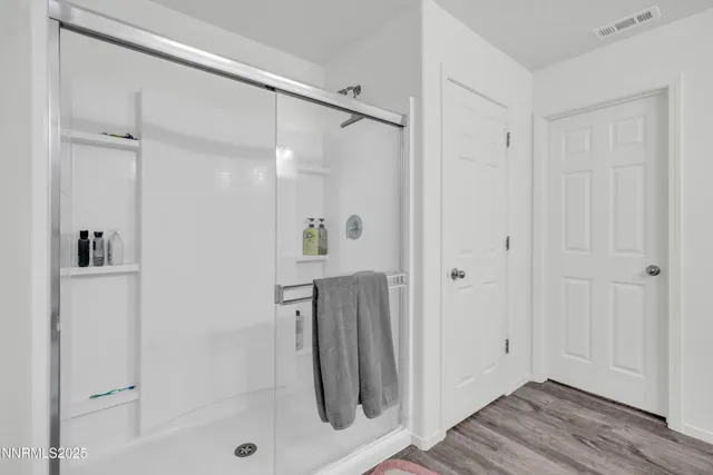 a bathroom with a shower and a glass door