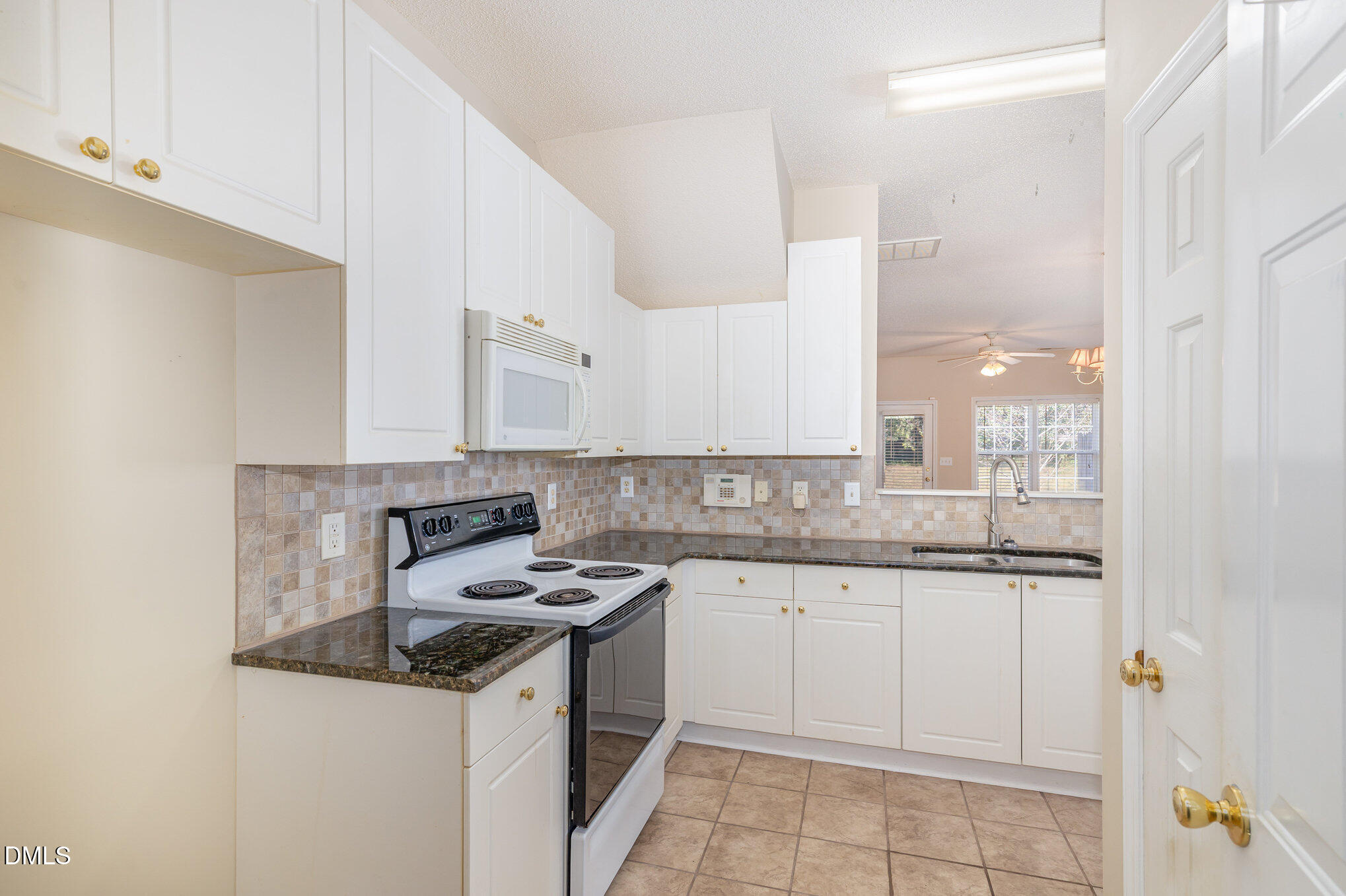 2116 Metacomet Way Raleigh, NC 27604 - Photo 9 of 24 a kitchen with granite countertop a sink a stove and cabinets