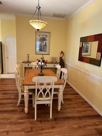 a dining room with furniture a chandelier and wooden floor