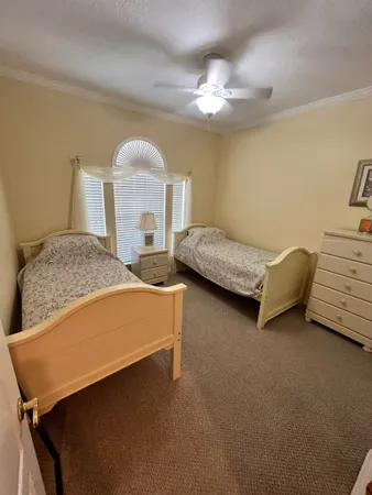 a bedroom with two beds and chandelier
