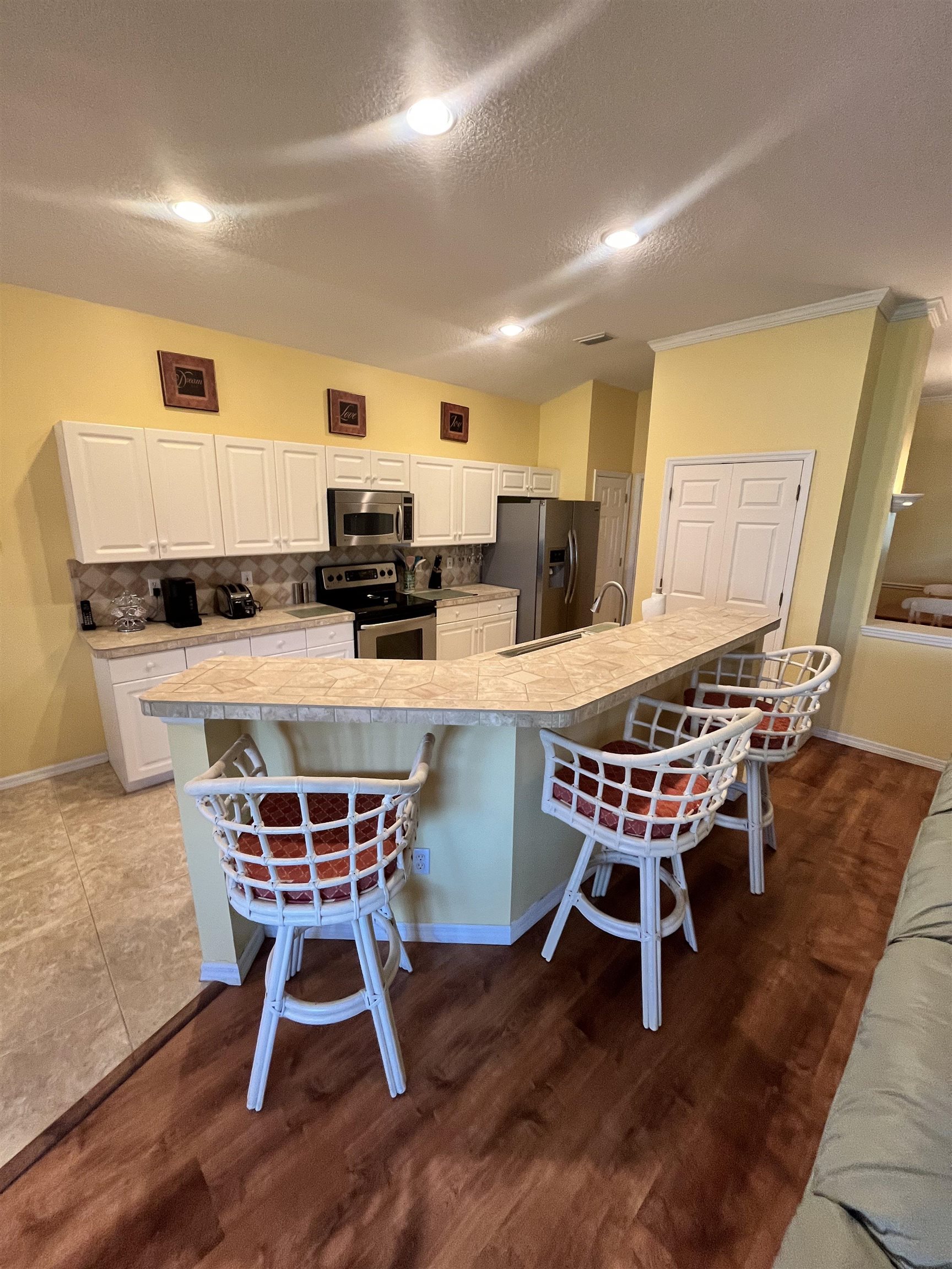 613 Casa Fuerta Lane St. Augustine, FL 32080 - Photo 9 of 23 a dining room with stainless steel appliances kitchen island granite countertop a table chairs and a refrigerator