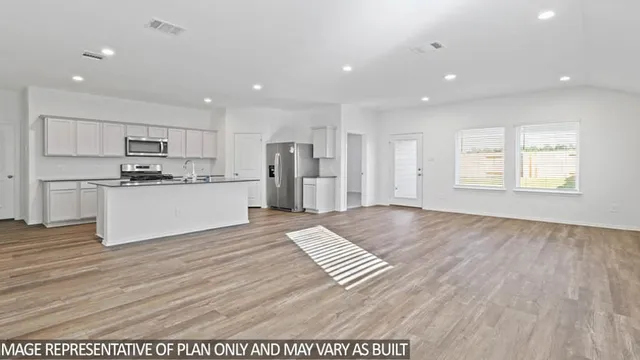 a view of kitchen with stainless steel appliances refrigerator sink and cabinets