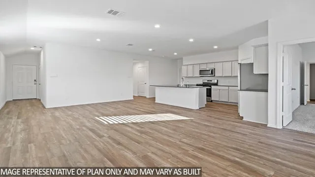 a view of kitchen appliances wooden floor and windows