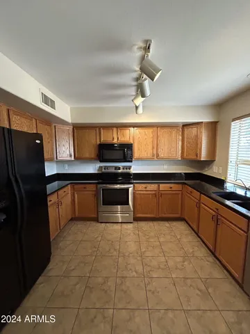 a large kitchen with a stove a sink dishwasher and a refrigerator