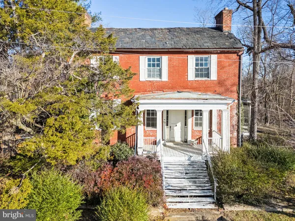 a view of a brick house with a large windows and flower plants