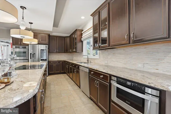 a kitchen with stainless steel appliances granite countertop a stove oven and a sink