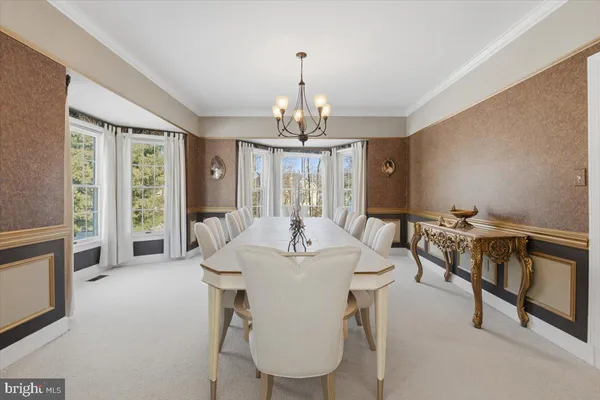 a kitchen with stainless steel appliances granite countertop a stove top oven a sink dishwasher a dining table and chairs with wooden floor