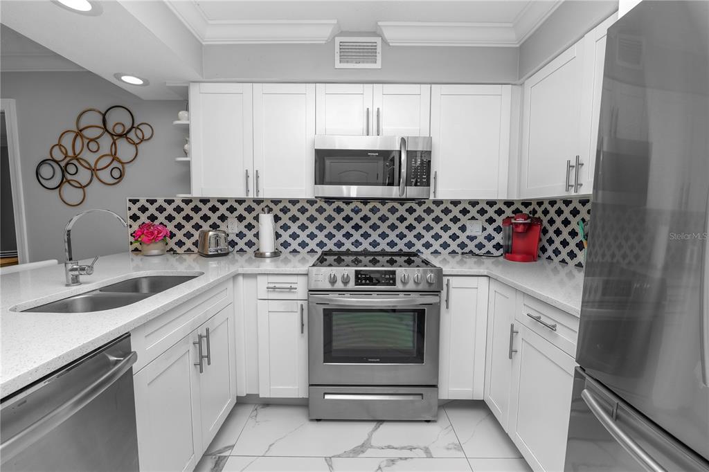 4947 Mill Pond Road, Unit 3103 & 3105 Wesley Chapel, FL 33543 - Photo 29 of 46 a kitchen with a sink stove and microwave