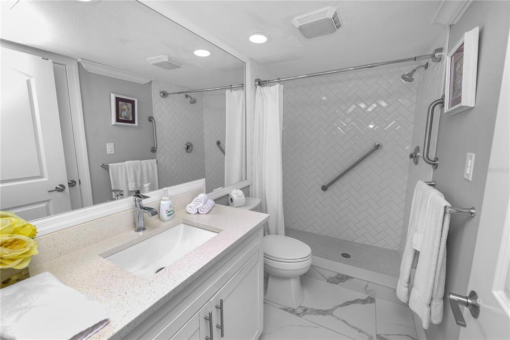4947 Mill Pond Road, Unit 3103 & 3105 Wesley Chapel, FL 33543 - Photo 35 of 46 a spacious bathroom with a granite countertop sink toilet and shower