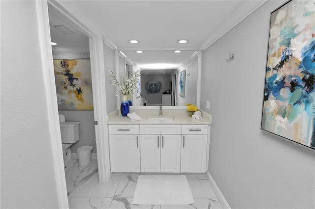 a spacious bathroom with a granite countertop sink a toilet a mirror and vanity