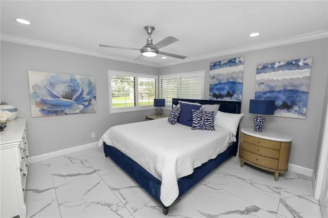 a large bedroom with bed and paintings on the wall