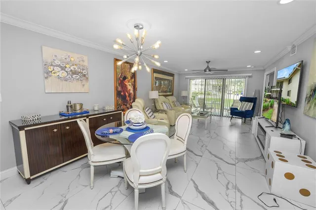 a living room with furniture a flat screen tv and kitchen view