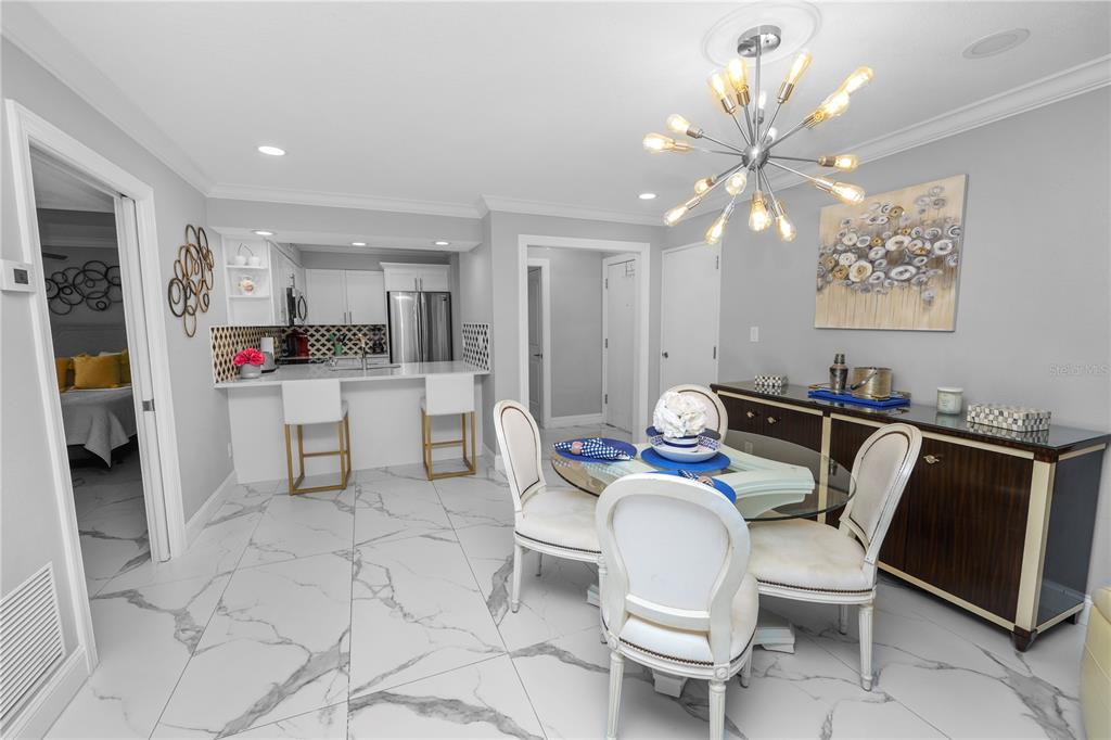 4947 Mill Pond Road, Unit 3103 & 3105 Wesley Chapel, FL 33543 - Photo 45 of 46 a kitchen with stainless steel appliances kitchen island granite countertop a table chairs and a refrigerator