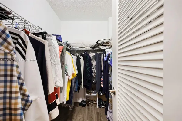 a view of walk in closet with clothes and shoes