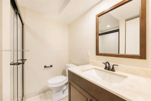a bathroom with a sink toilet vanity and shower