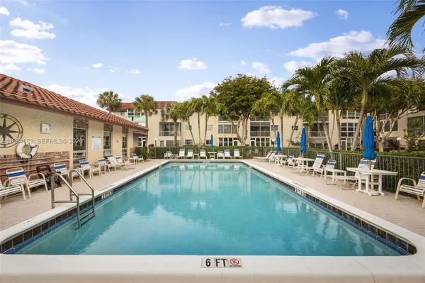 a view of a house with swimming pool and sitting area