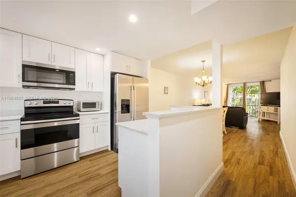 a kitchen with a refrigerator and a stove top oven