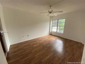 4166 Inverrary Drive, Unit 303 Lauderhill, FL 33319 - Photo 6 of 12 an empty room with wooden floor fan and windows