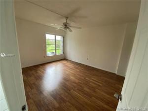 4166 Inverrary Drive, Unit 303 Lauderhill, FL 33319 - Photo 9 of 12 an empty room with wooden floor and windows