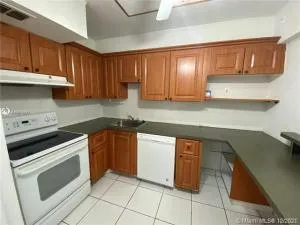 a kitchen with a cabinets and white appliances