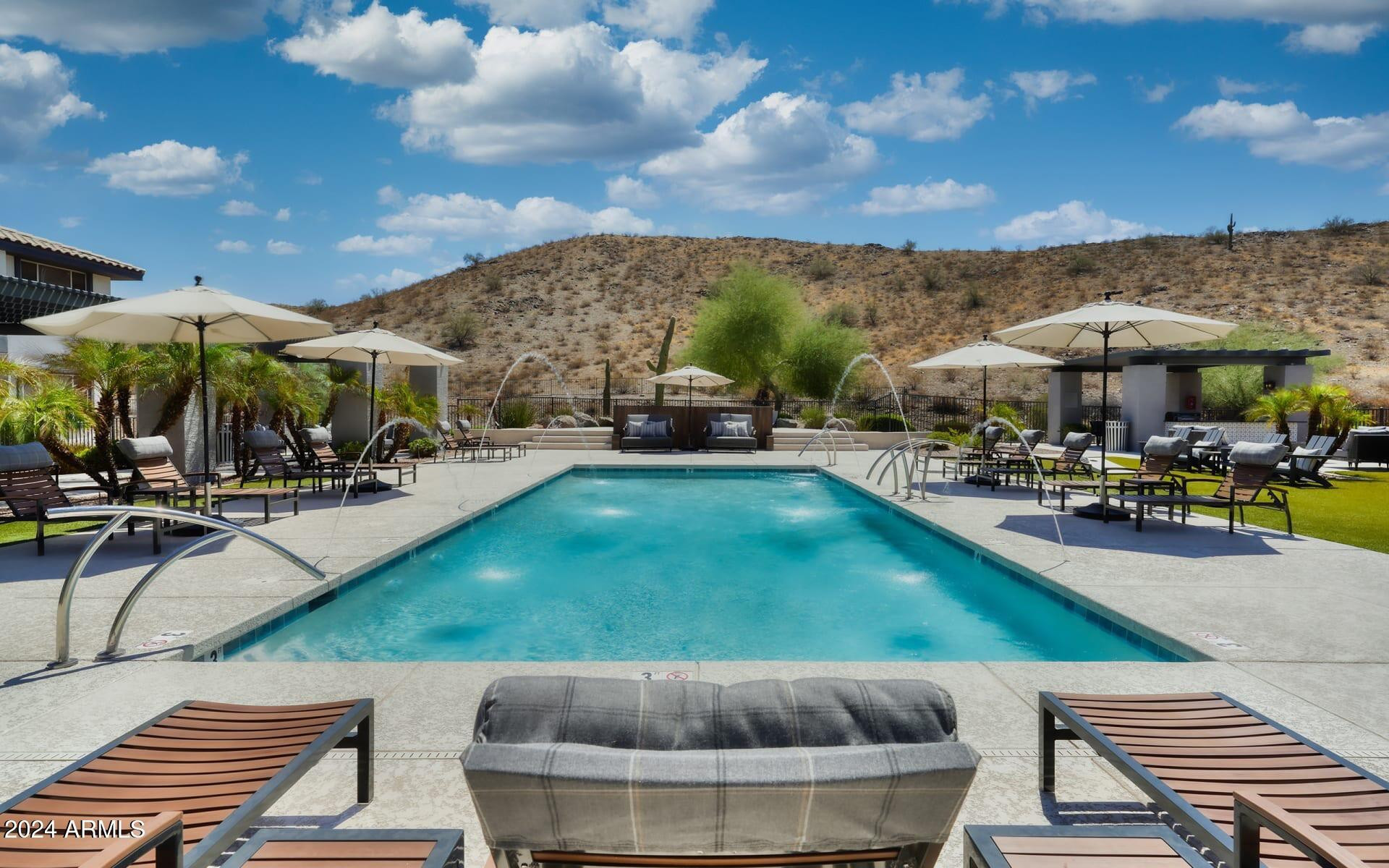 a swimming pool with outdoor seating and a garden